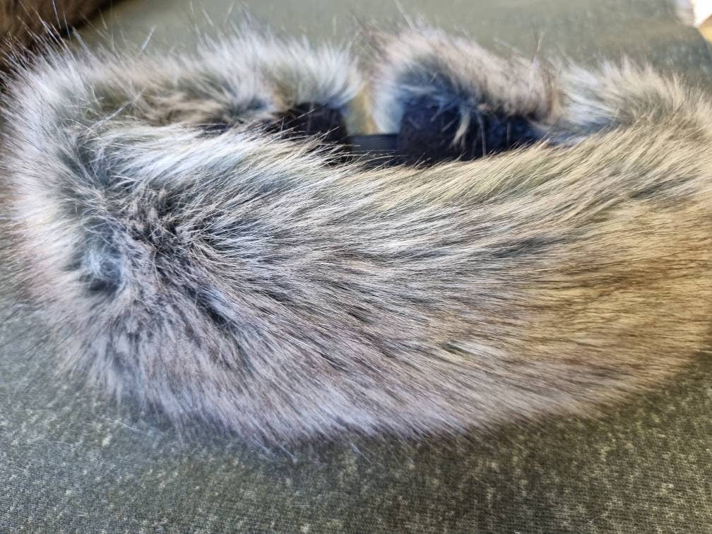 close up of fluffy faux fur headband in shades of light brown and grey