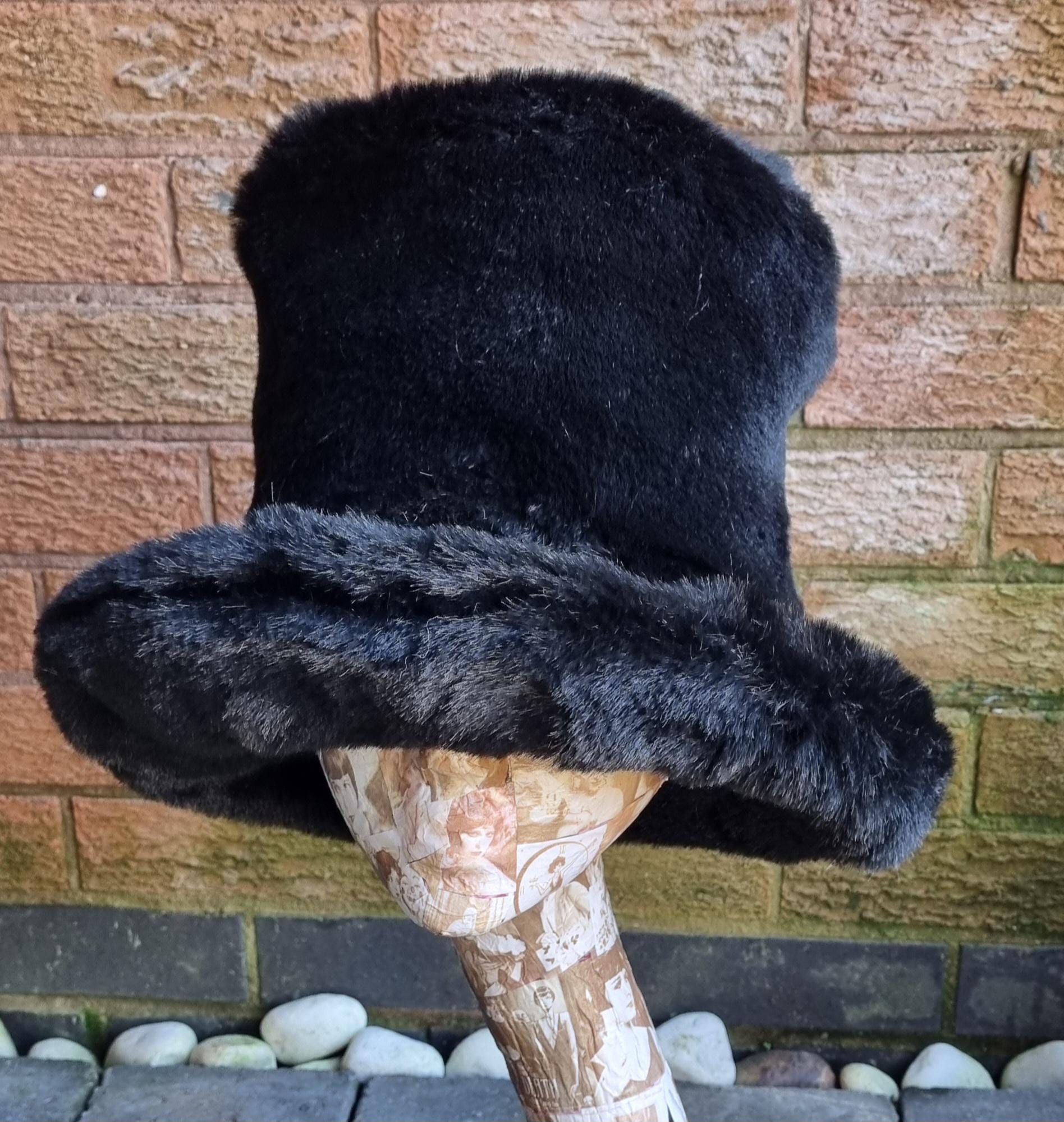 Black fur hat on a mannequin head against a brick wall.
