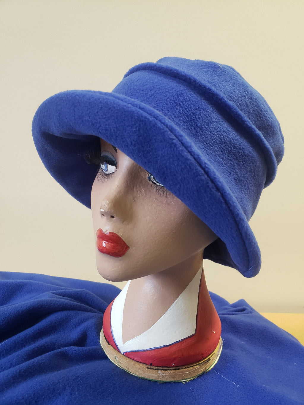 Mannequin head wearing a blue hat with a plain background
