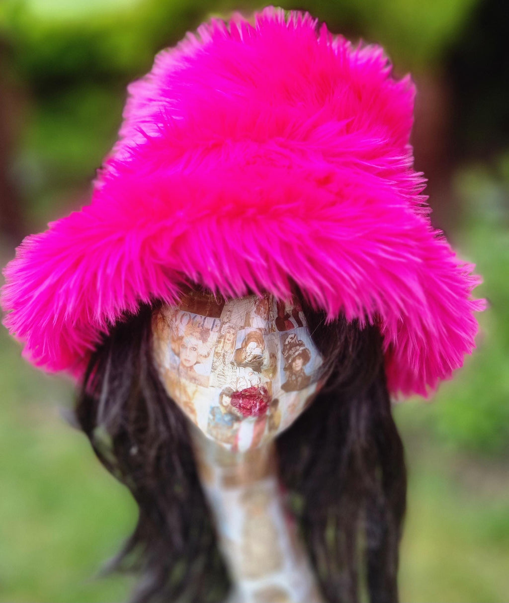 Person wearing a bright pink fluffy hat with a blurred green background