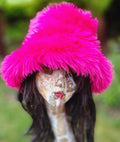 Person wearing a bright pink fluffy hat with a blurred green background