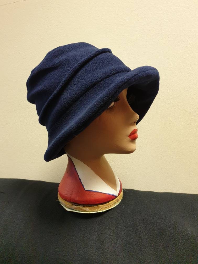 Navy blue hat on a mannequin head against a beige background