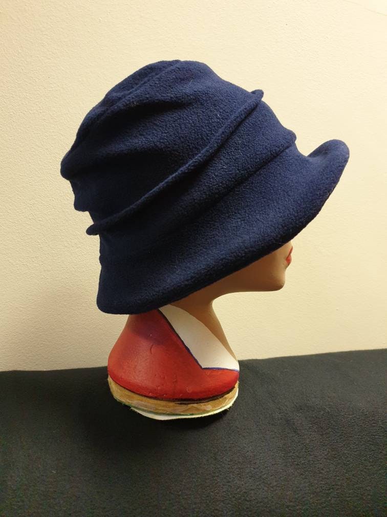 Navy blue hat on a mannequin head against a beige background
