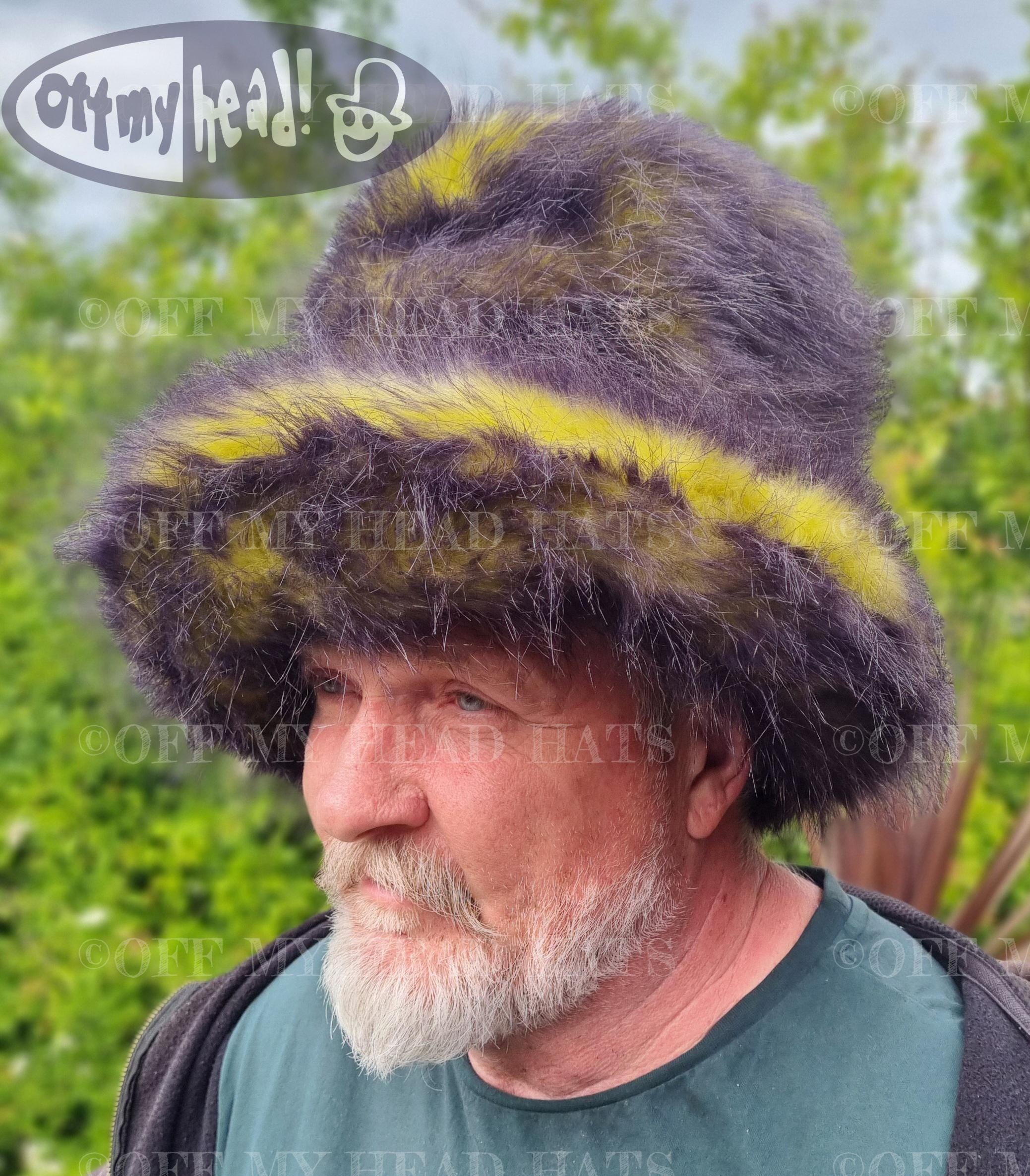 Man wearing a large, fluffy hat with yellow and black.
