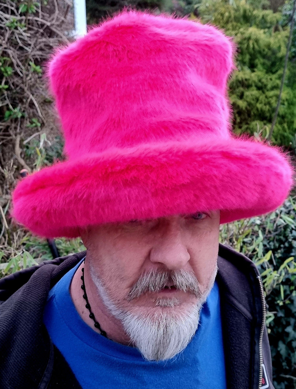 Person wearing a bright pink fur hat tall oversized hat