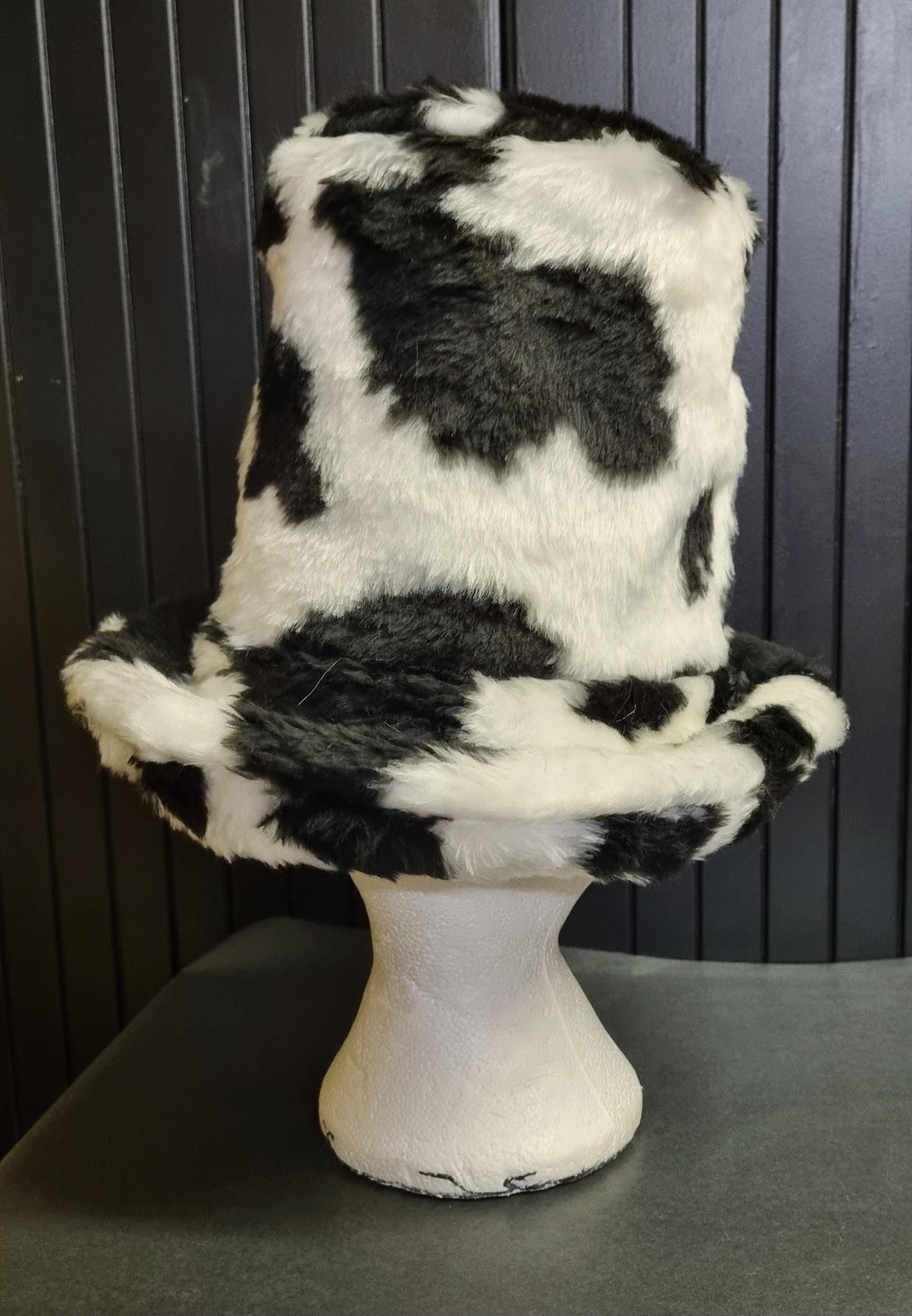 Black and white cow print hat tall with a wide brim