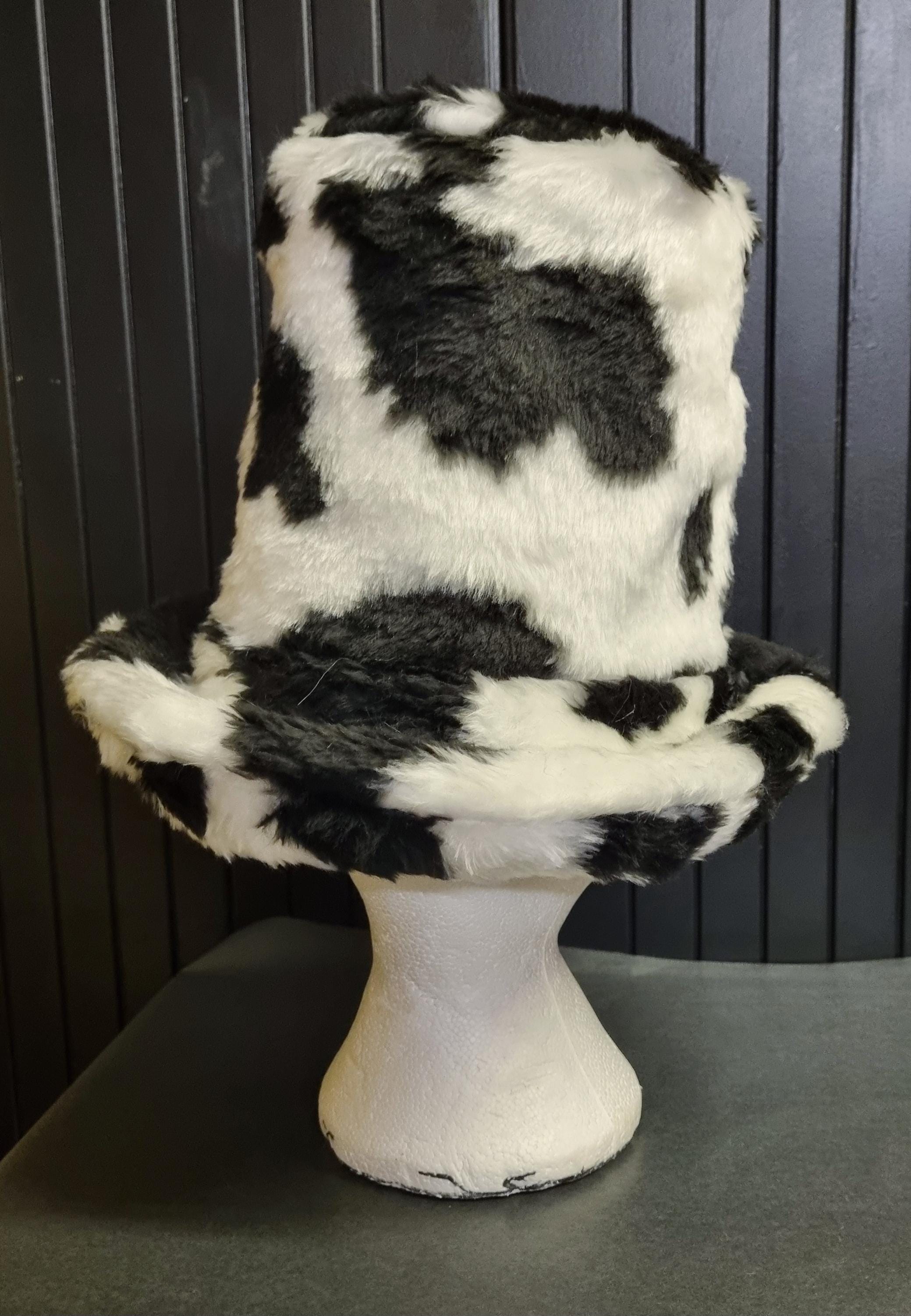Black and white cow print hat tall with a wide brim