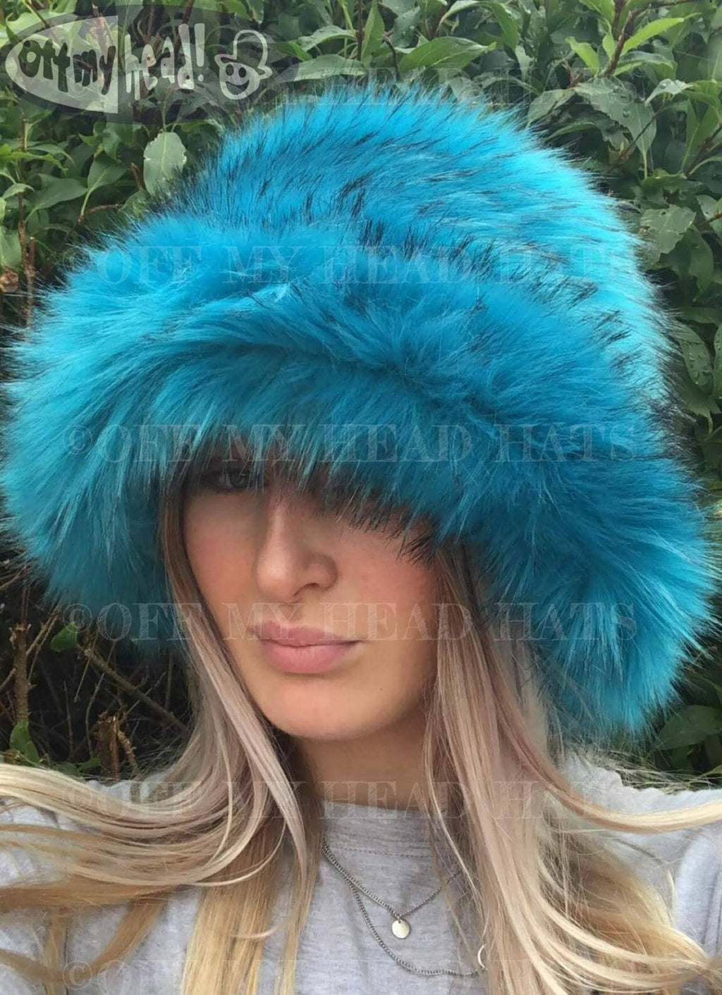 Turquoise and black faux fur bucket hat — front view worn by a person, rich turquoise long-pile fur with subtle black-tipped strands, handmade in the UK