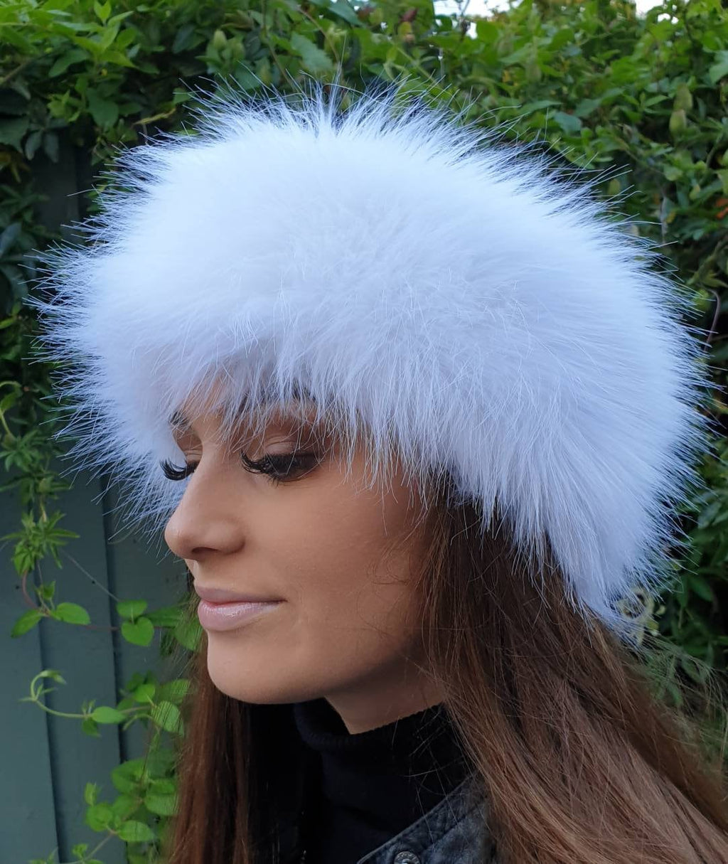 Woman wearing a white furry headbandwith a green outdoor background